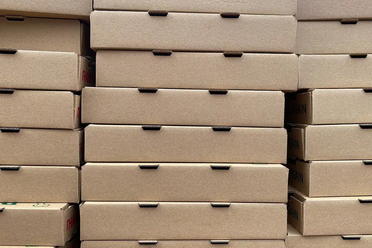 Cutie de pizza din carton pătată cu grăsime, ambalaj murdar care nu se mai reciclează