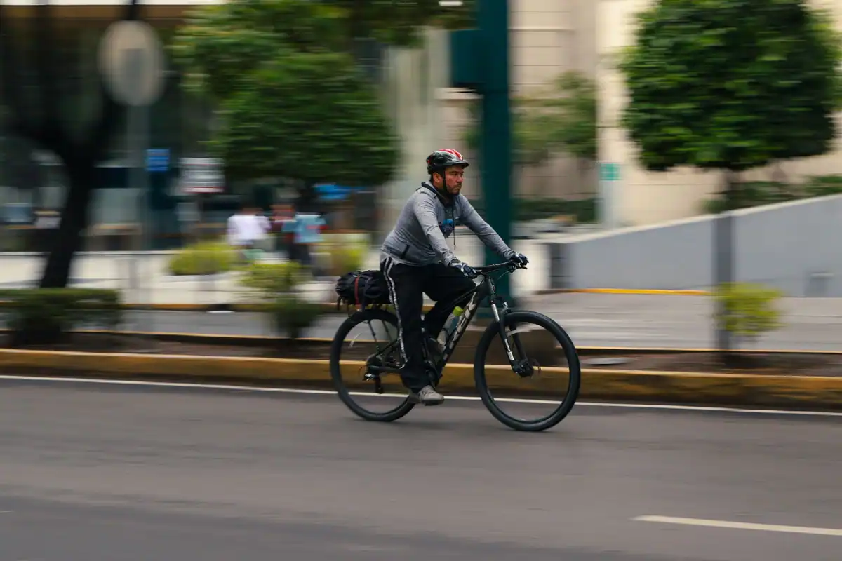 Bărbat pe bicicletă pe străzile orașului, alternativă la deplasarea cu mașina
