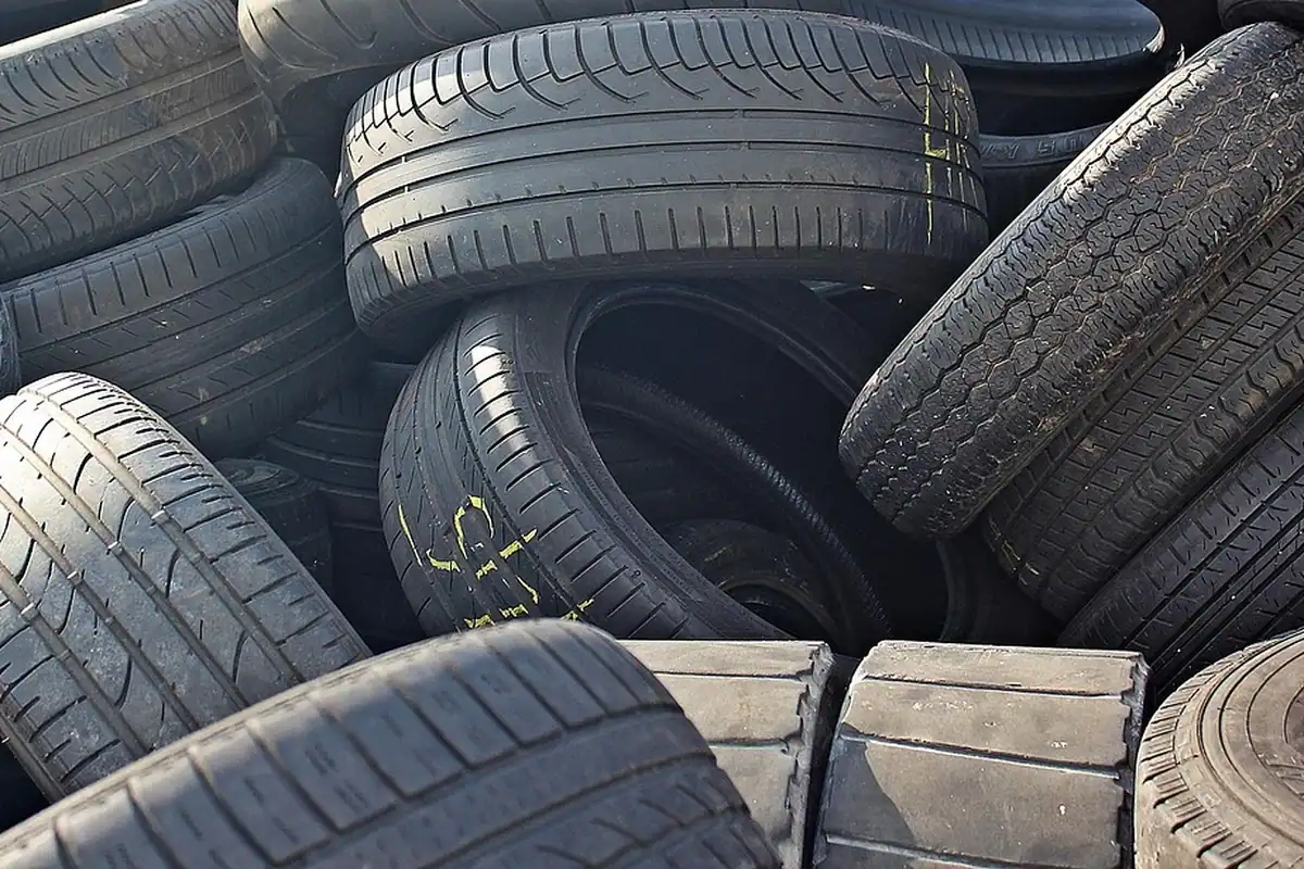 Teanc de anvelope uzate într-o curte de depozitare, pregătite pentru predare la reciclare