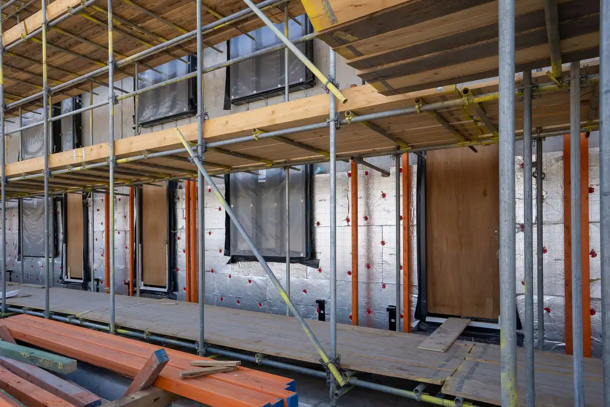 Schelă pe o clădire rezidențială în renovare, cu plăci de izolație termică vizibile