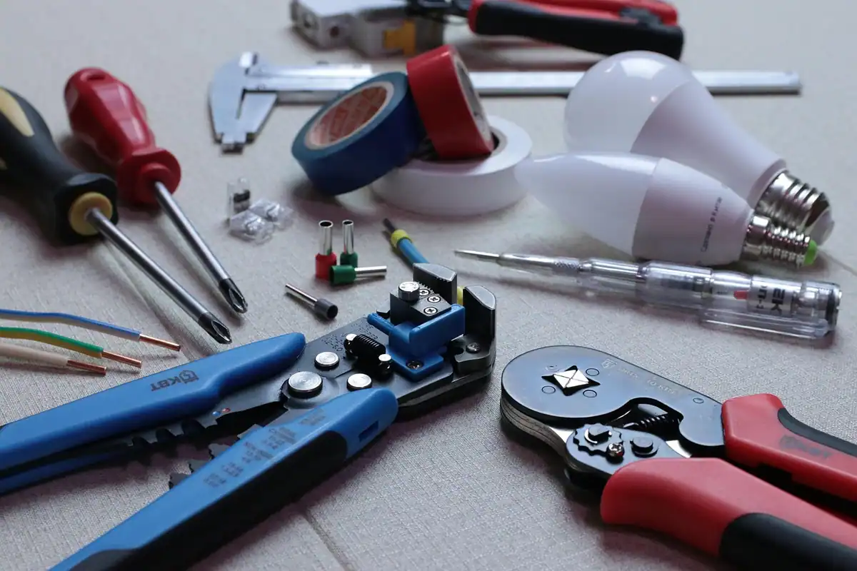 Unelte de electrician și becuri LED economice așezate pe o masă de lucru