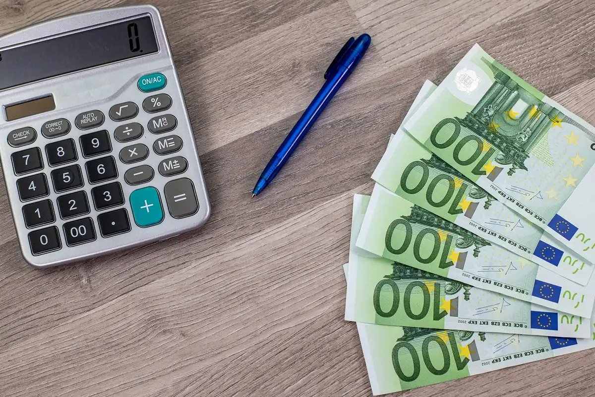 Facturi pe hârtie și un calculator pe un birou, citirea componentelor facturii de energie electrică