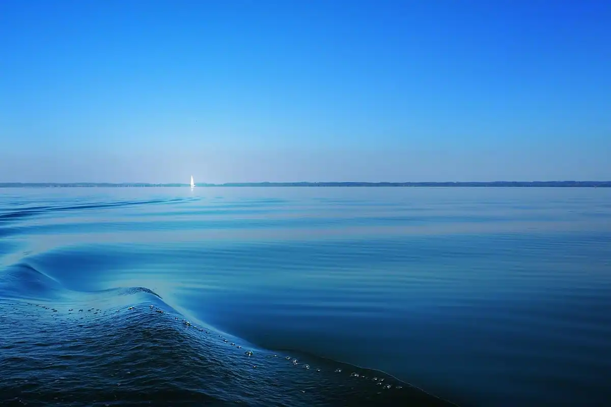 Valuri ale unui ocean albastru adânc până la orizont, ocean care absoarbe căldura și CO2