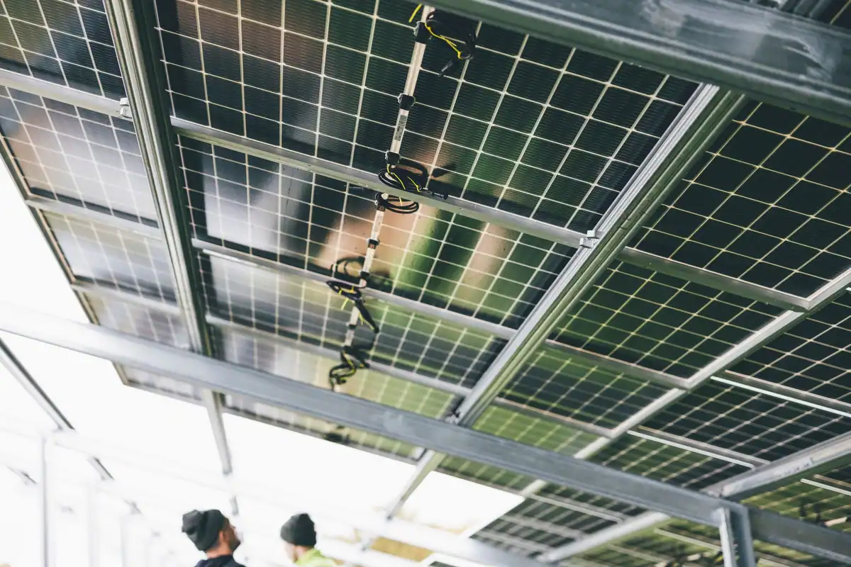 Tehnicieni care instalează panouri fotovoltaice în aer liber