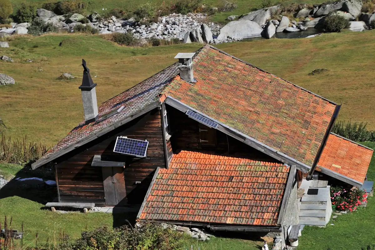 Căsuță roșie din lemn într-o pădure acoperită de zăpadă