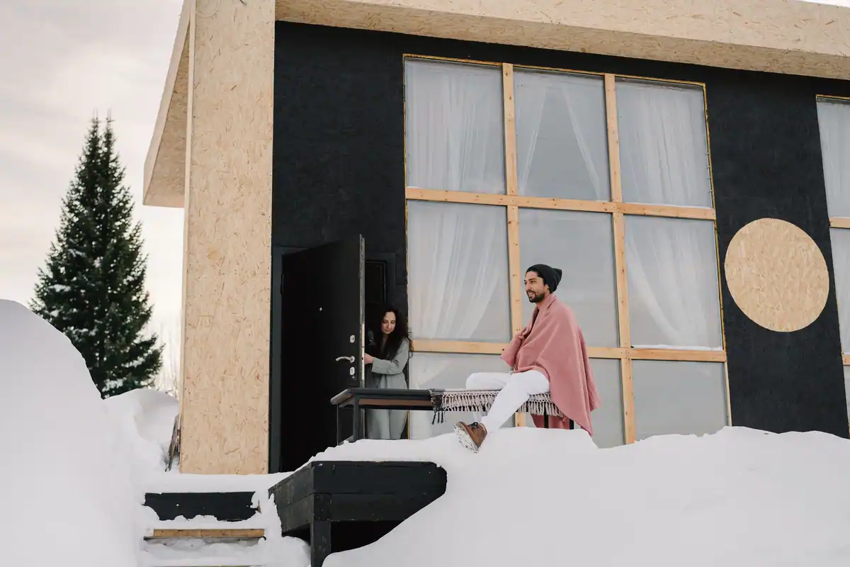 Casă modernă înconjurată de zăpadă, încălzită iarna cu o pompă de căldură