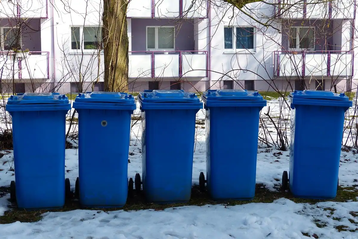 Coșuri de reciclare pentru sortarea deșeurilor în bucătăria unui apartament mic