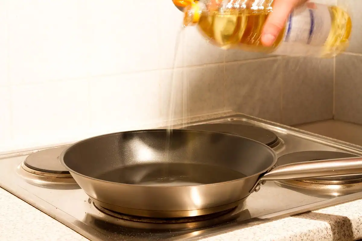 Ulei de gătit turnat într-o tigaie, ulei alimentar care rămâne uzat după prăjit
